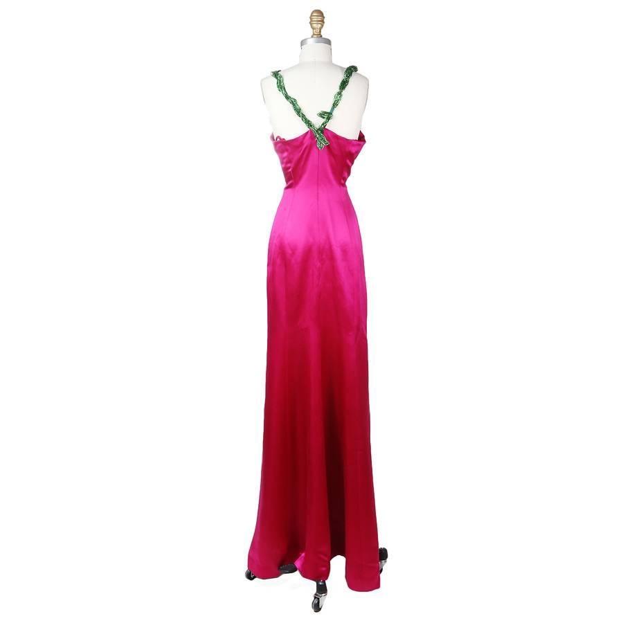 This is a gown by Todd Oldham from spring 1998.  It is made from fuchsia colored silk and features beaded flowers around the bust and green beaded straps.  The closure is an invisible zipper down the back with a hook and eye closure at the top.
