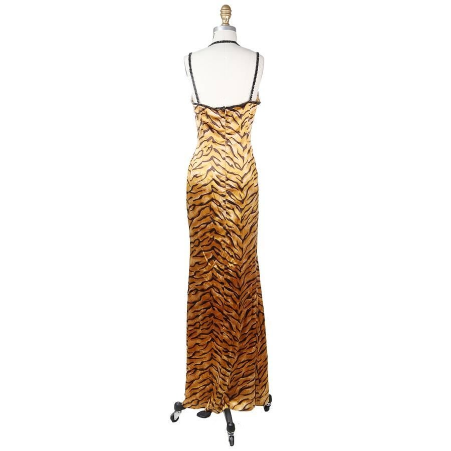 This is a long sheath cut silk dress by Todd Oldham from spring 1995.  It features a tan tiger print and black jeweled trim and straps.  The closure is an invisible zipper down the center back.
