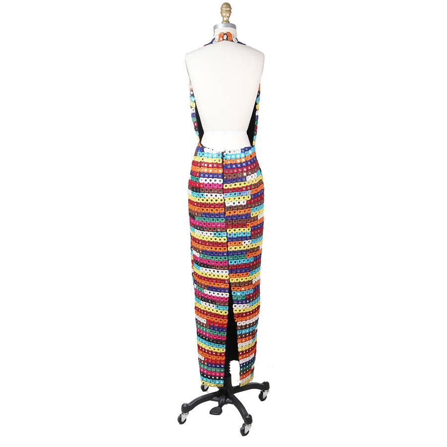 This is a halter neck gown by Todd Oldham from fall 1993.  It is comprised of tiles that are individually wrapped in various colored thread to border the reflective squares.  The closure is an invisible zipper down the center back, and the halter