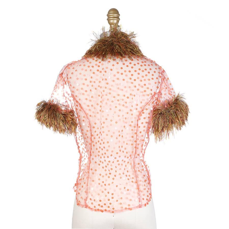This is a top by Todd Oldham from spring 1996.  It is made from a salmon colored fine mesh that is polka dotted in sequins and also features a multi color long threaded fur trim on the collar and sleeves. 

15.5" shoulder to shoulder