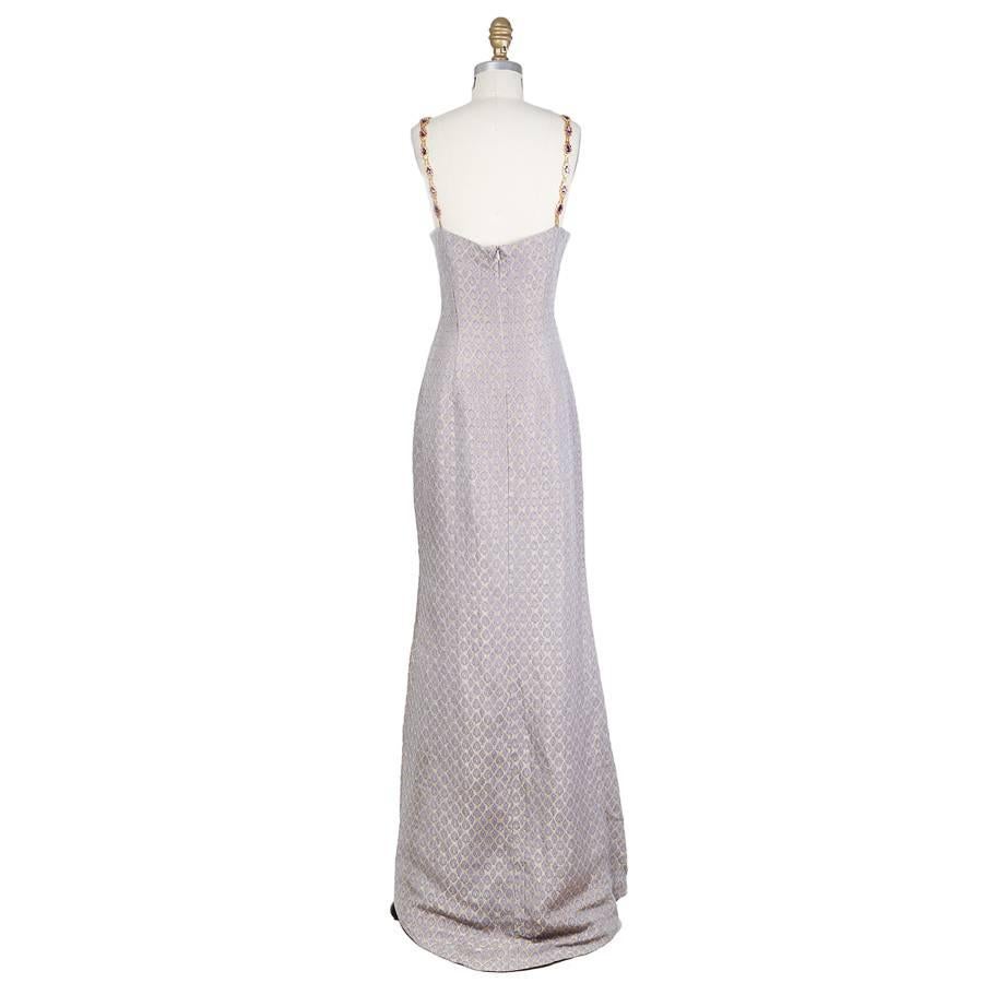 This is a brocade dress by Todd Oldham from spring 1998.  It features a regal print in lavender and a gold chain strap with purple jewels.  The closure is an invisible zipper down the center back.