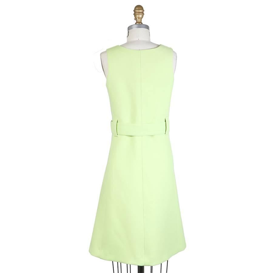 This a bright mint green shift dress by Courreges c. 1960s.  It features an asymmetrical font button closure with a matching belt with large belt loops.  It is lined in a matching green satin.  