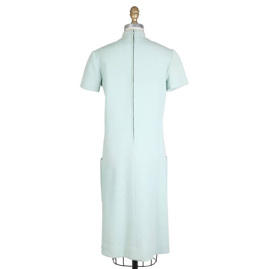 This is a wool shift dress by Norman Norell c. 1960s.  It features a mock turtleneck collar, two waist pockets, and a matching colored satin lining.  The closure is a hidden zipper down the back with a top hook and eye closure.  

14.5