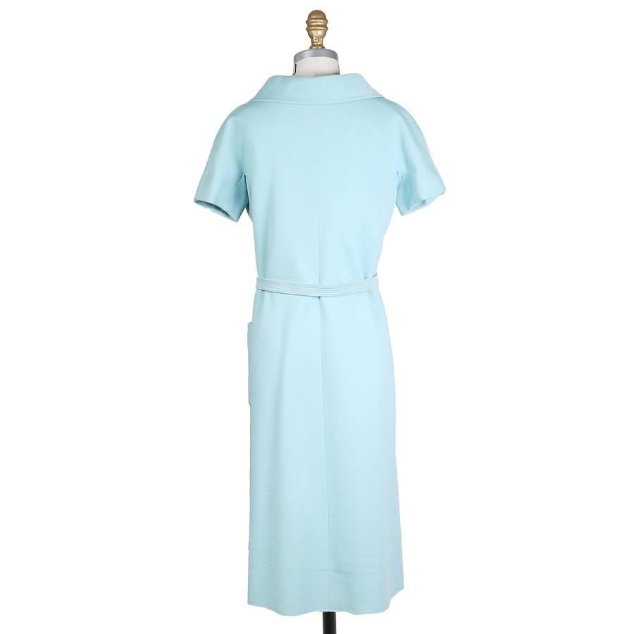 This is a shift dress by Norman Norell c. 1960s.  It features short sleeves, two waist pockets, a large collar and large buttons, and includes a matching web belt.  It also has a matching colored satin lining. 