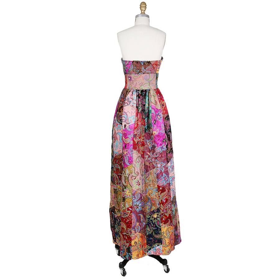 This is a dress by Oscar de la Renta from his fall 2002 collection.  It is strapless with a fitted waist and full skirt.  It features a patchwork of embroidered silk tapestries.  The bustier is structures inside and has a hidden side zipper with a
