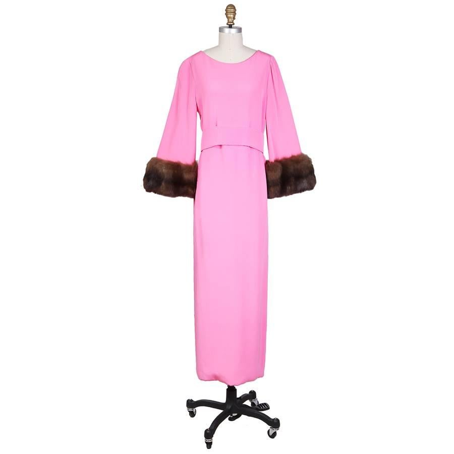 This is a dress and dust coat by Norman Norell c. 1960s.  The dress has 3/4 sleeves with fur cuffs and comes with a matching sleeveless dust coat with a long fur trim collar that is worn over the dress like a long vest.  The dress is also lined in
