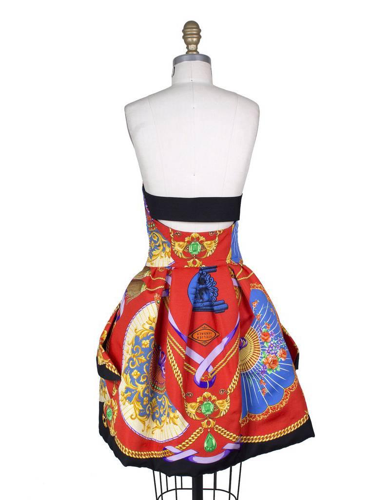 This is a dress by Gianni Versace.  It features a baroque style print and large gold buttons.