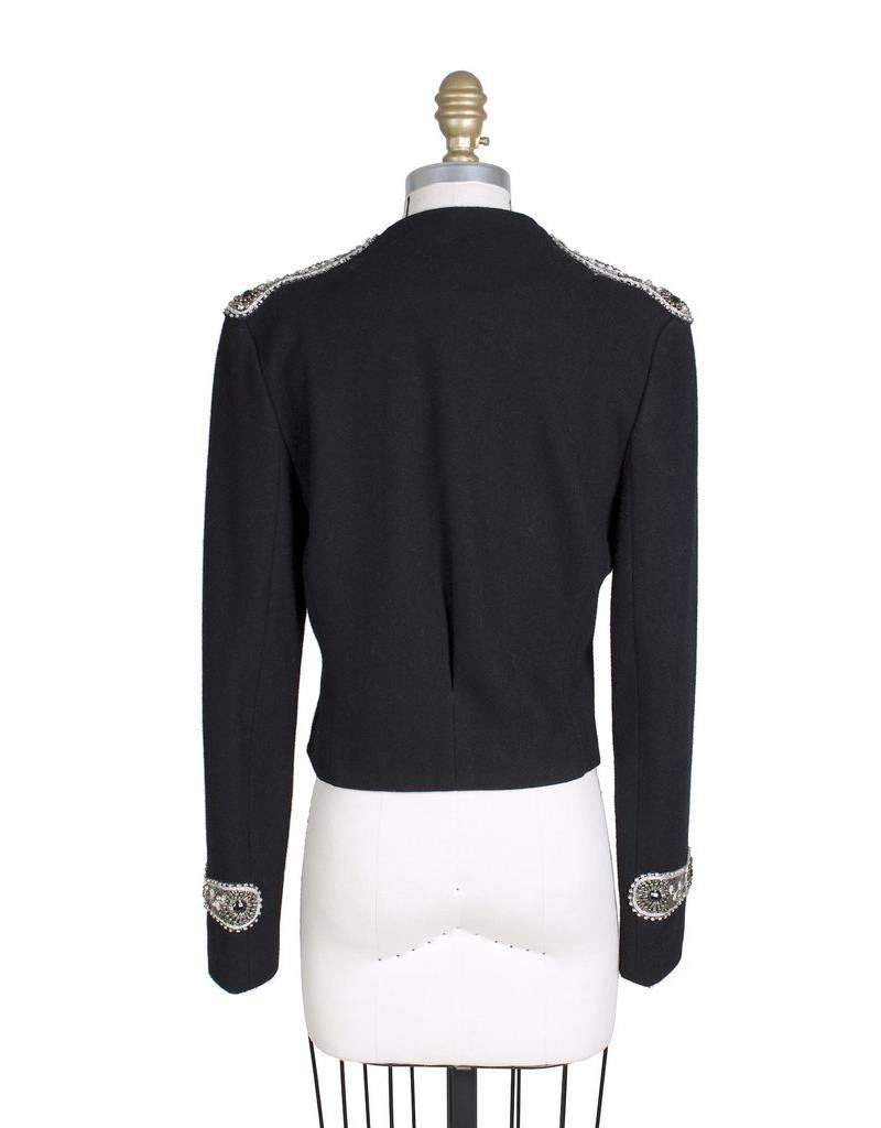 This is a wool military style jacket by Balmain.  It features a cropped fit and embellishment details on the shoulders, cuffs, and front.  It also has 3 hidden snap closures in front. 

15.5