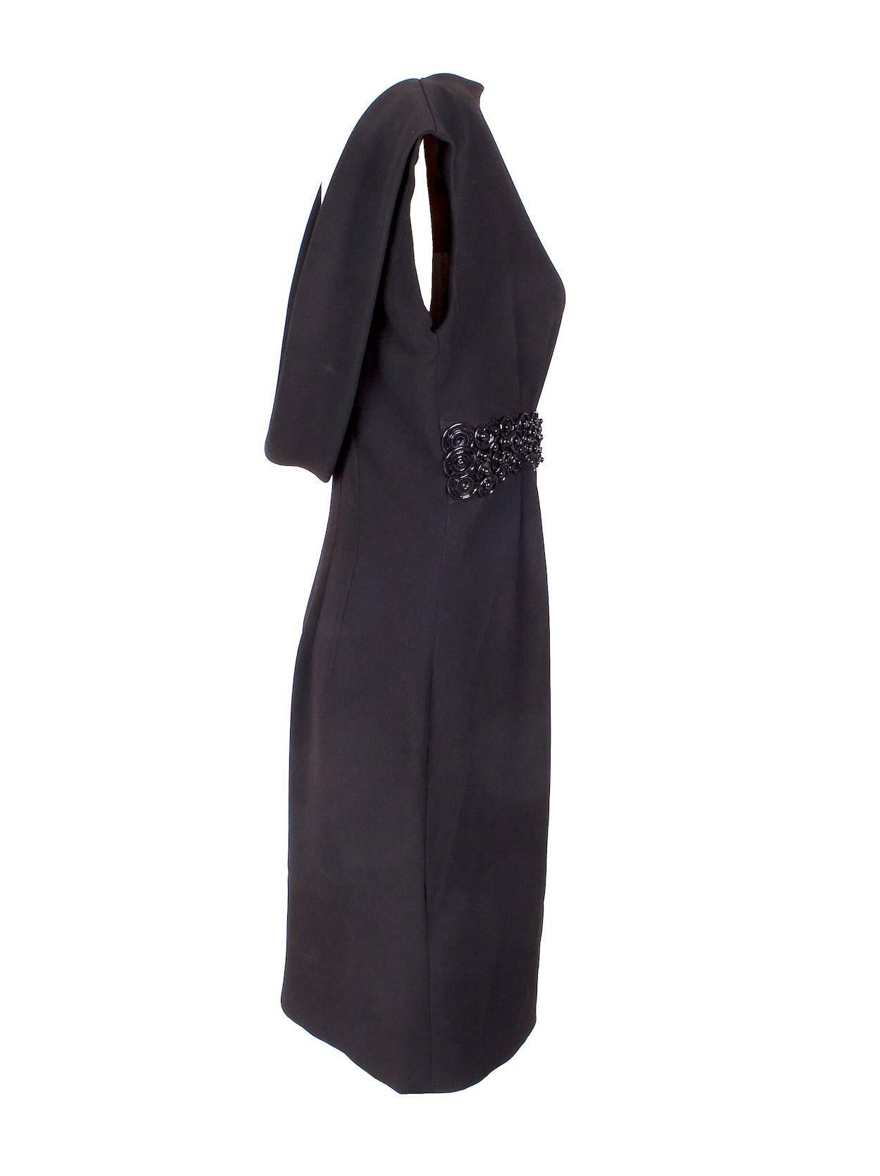 This is a black dress by Jean Paul Gaultier with a cowel drape back and button detailing belt.  