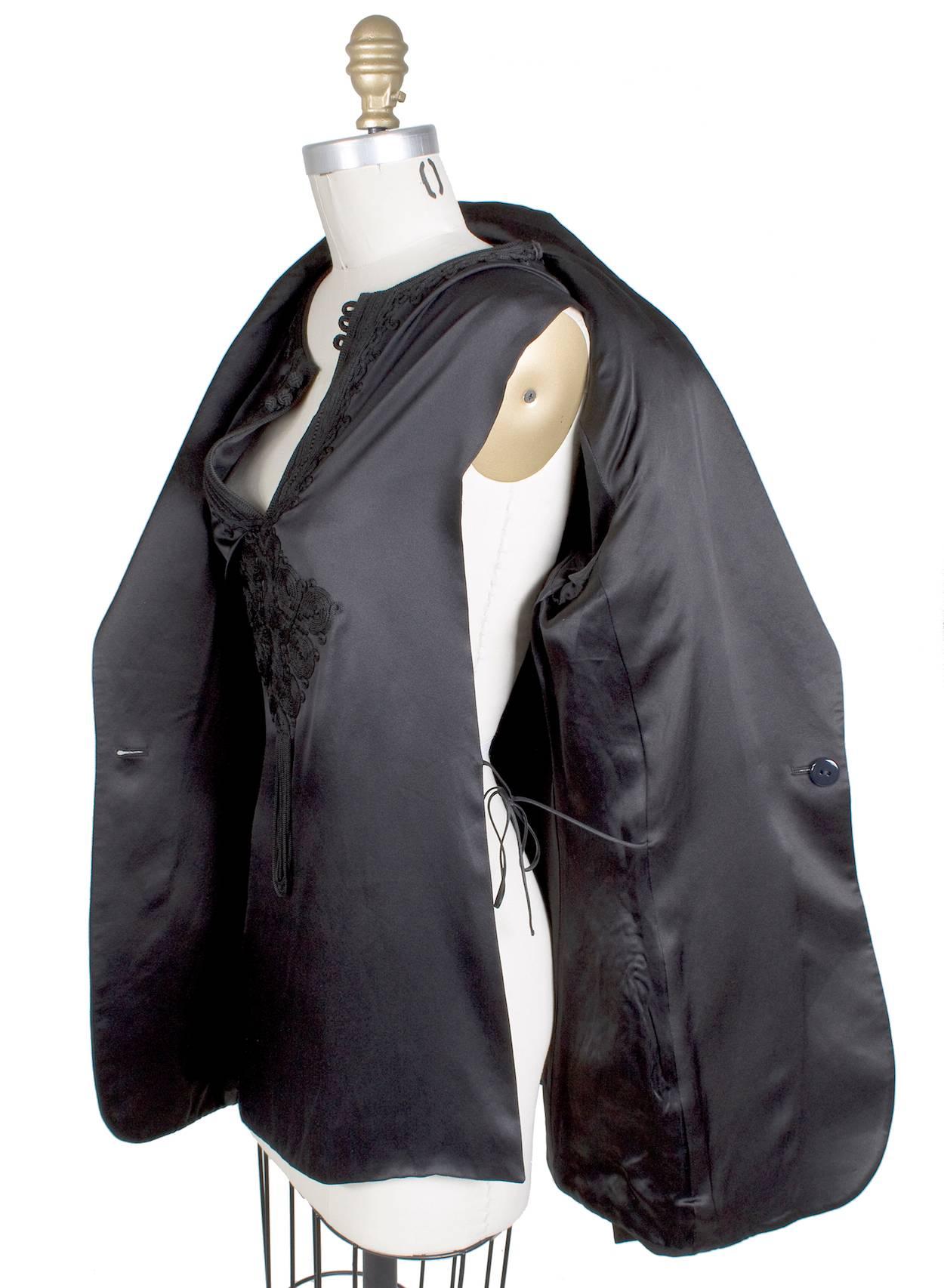 This is a black blazer by Jean Paul Gaultier c. 1990s.  It features an attached silk shirt that is embroidered with a thick thread.  

16" shoulder to shoulder
26" long sleeves