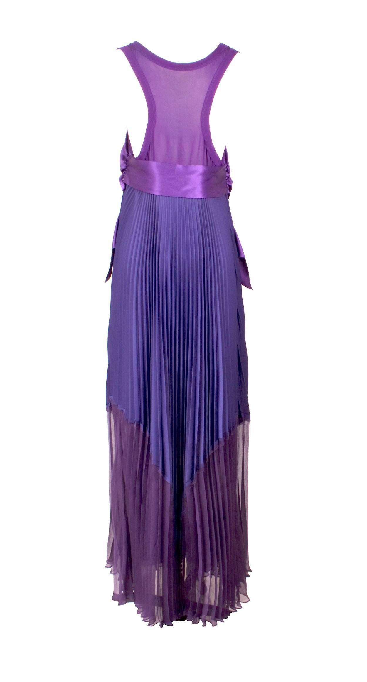This is a purple dress by Jean Paul Gaultier c. 1990s.  It features a large silk satin bow in front as well as a sheer silk bodice and pleated chiffon skirt.  