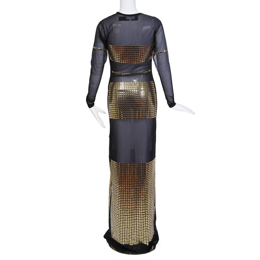 This is a long sleeve dress by Todd Oldham c. 1990s.  It features a fine black mesh body with panels of gridded gold buttons placed for coverage.  

14" shoulder to shoulder
22" sleeve length