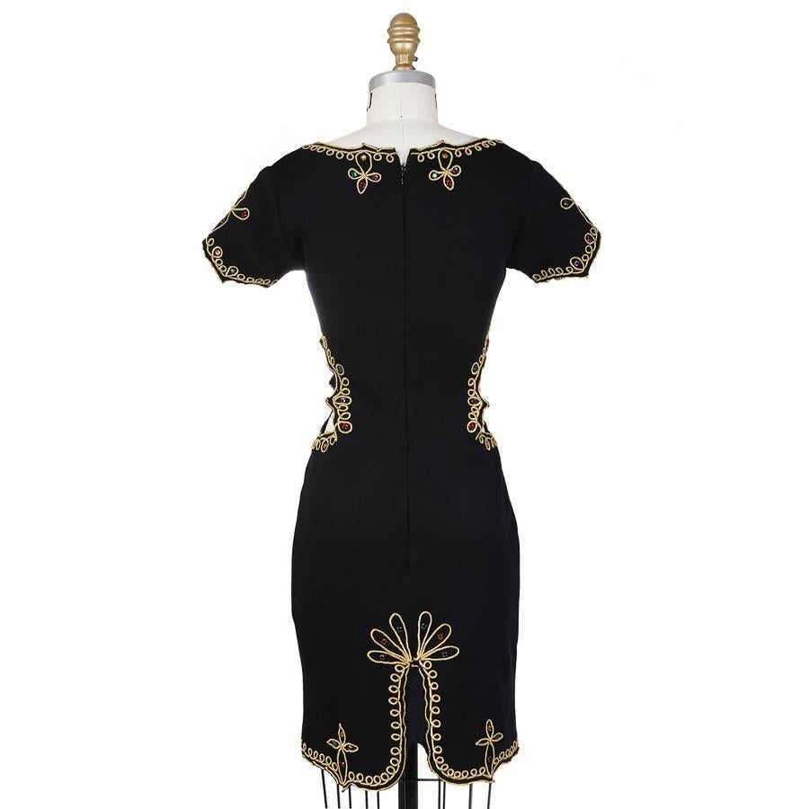 This is a wool dress by Todd Oldham c. 1990s.  It features ornate gold trimming with various colored jewel accents.  

15" shoulder to shoulder
6" sleeve length