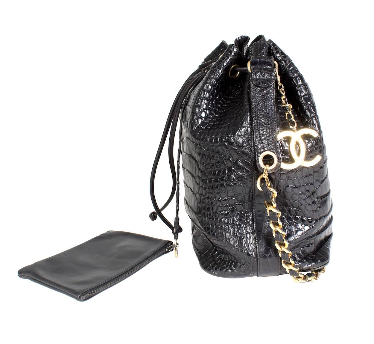 Black croc bucket bag by Chanel from 1990.  It features gold hardware and a leather drawstring closure on top.  It includes an attached leather wallet.  Rare/collectible item.

20