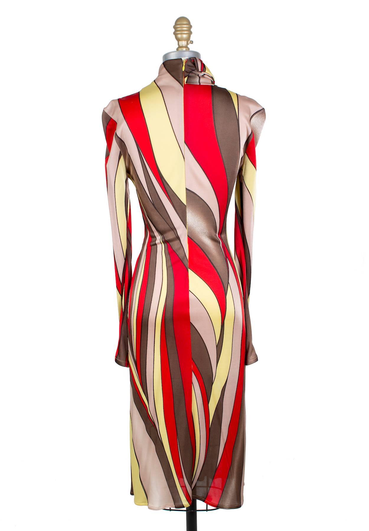 This is a stretch jersey dress from Versace circa 1990s.  It features a red yellow and brown curve print.  It has a high mock turtleneck collar with a twist knot detail.  The closure is a hidden zipper down the back.  

16