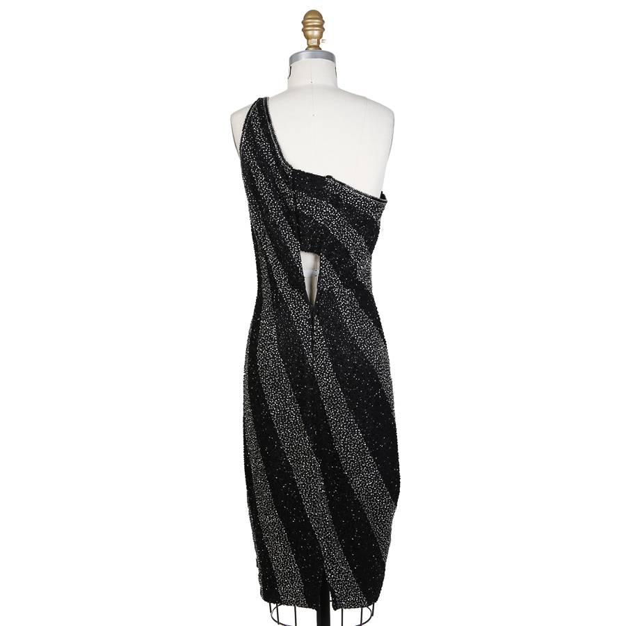 This is a one shoulder dress by Bob Mackie circa 1980s.  It features black and silver beads to create a cascading stripes design from one shoulder.   