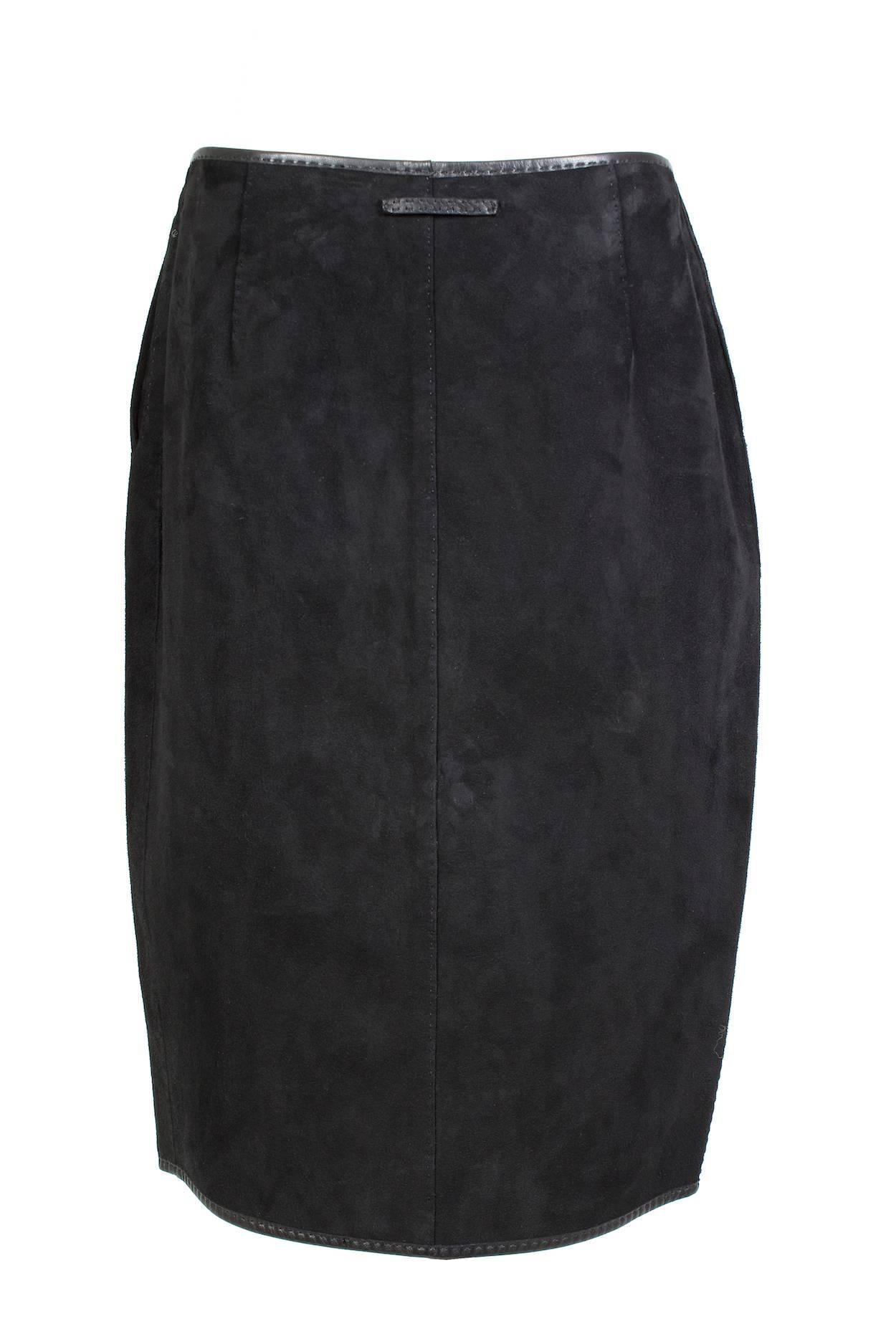 This is a black suede skirt by Jean Paul Gaultier circa 1990s.  It features black leather trim and has a full length double zipper down the front.  It also has twist lock closures down the center front which can be used to alter the shape and waist