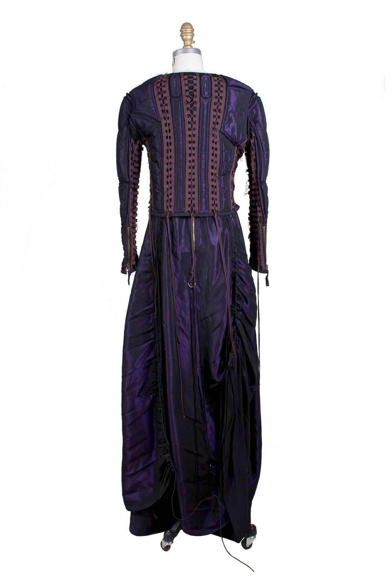 This is a matching gown and jacket by Jean Paul Gaultier c. 1990s.  It's made from a purple/black taffeta and features woven nylon lacing details similar to those used in army/navy apparel and accessories.  The jacket is structured and padded