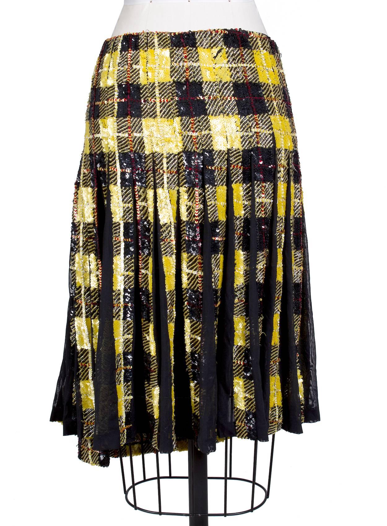 This is a skirt by Jean Paul Gaultier circa 2000s.  It features a plaid pattern made entirely from sequins and features back pleating with mesh panels.  Snap waist closure.  
