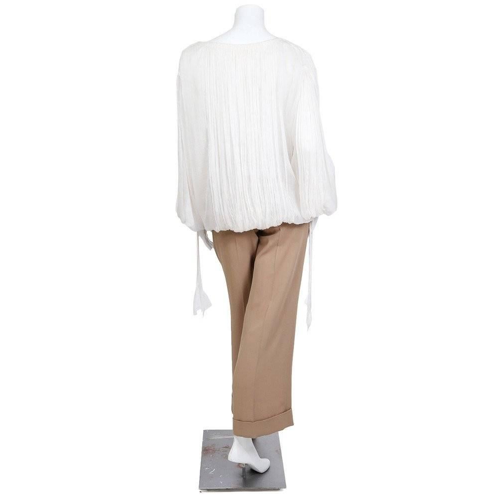 This is a blouse and pants set by Jean Paul Gaultier circa 1990s/2000s.  The blouse has a bubble hem, pleating, and ti closures for the neck and cuffs.  The pants are pleated and have cuffs as well as a zipper closure with hook and eye. 

Top:
21
