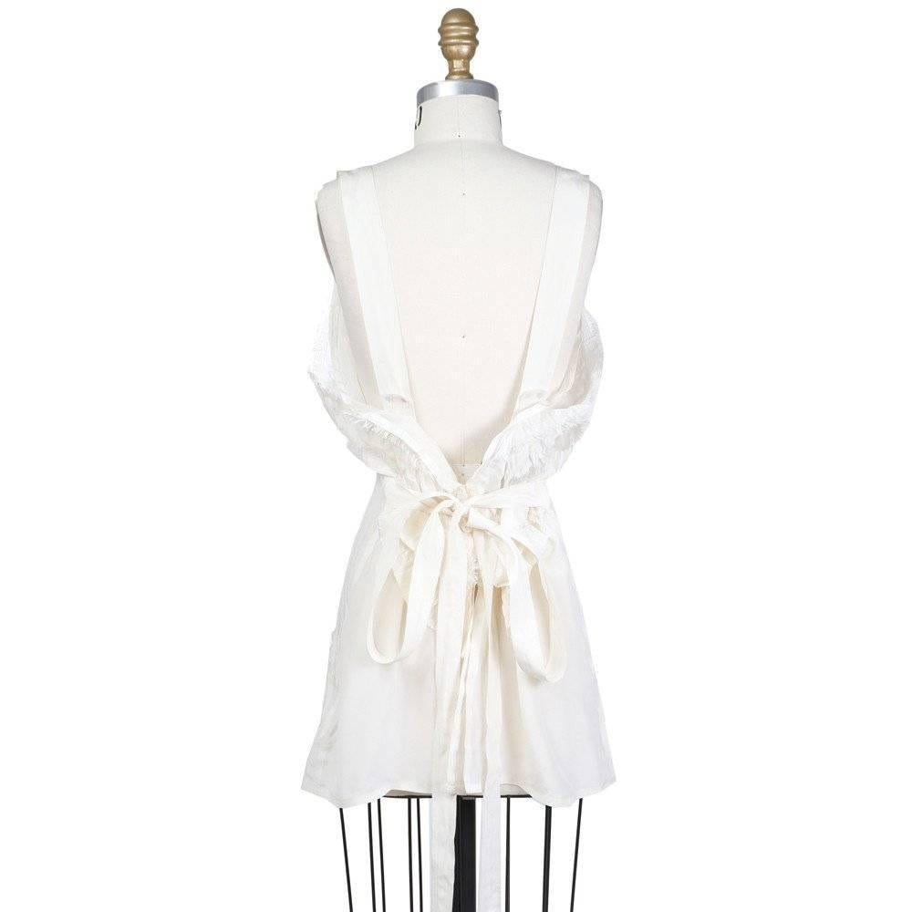 This is a silk top by Jean Paul Gaultier c. 1990s/2000s.  It features a ruffle that gathers under the bust and continues to the back, where it ties and buttons closed.  
