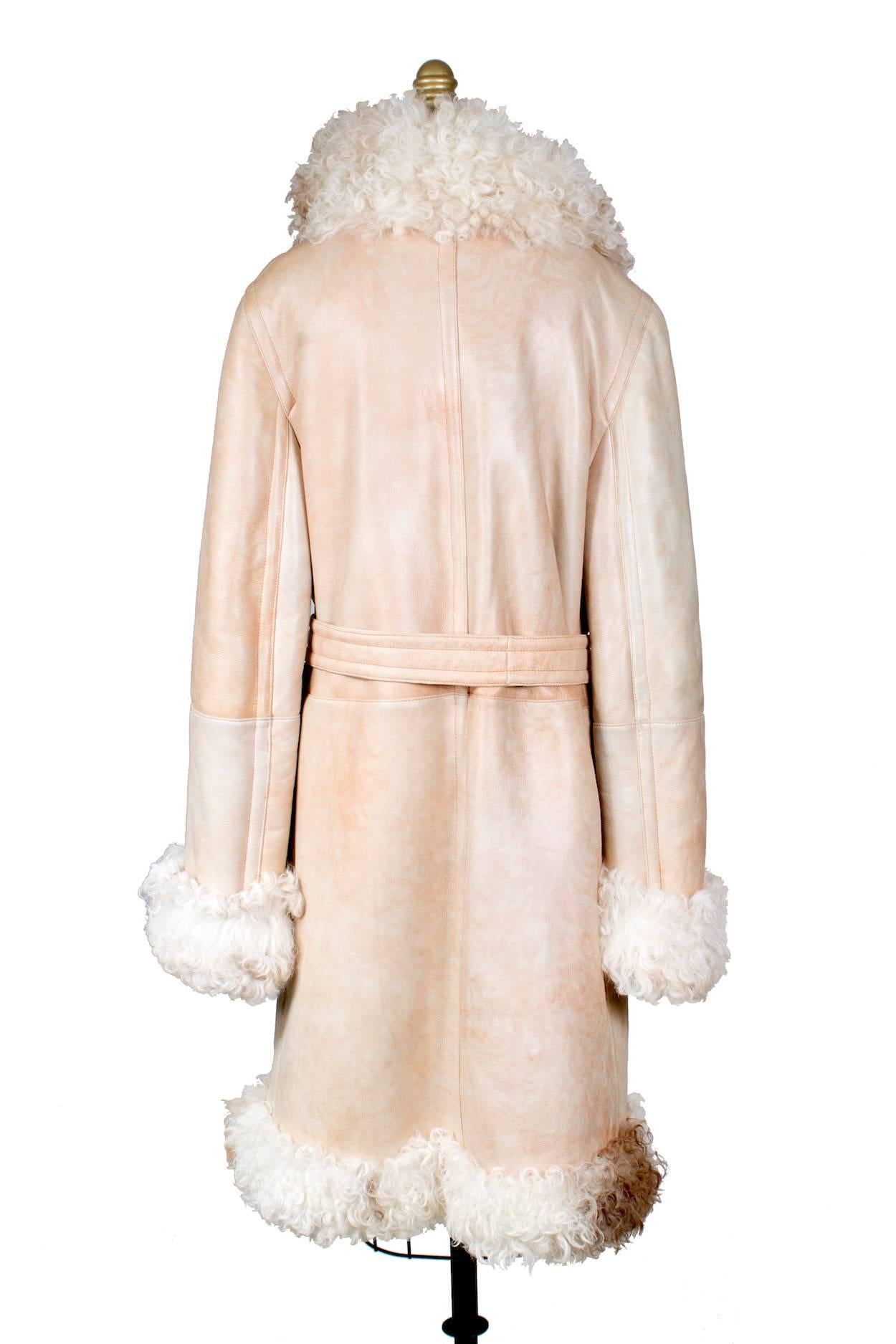 This is a shearling coat by Fendi.  It features curly fur and lambskin.  The closure in the front is gold belt buckles.  The jacket also has two front pockets and includes a separate belt.  

18