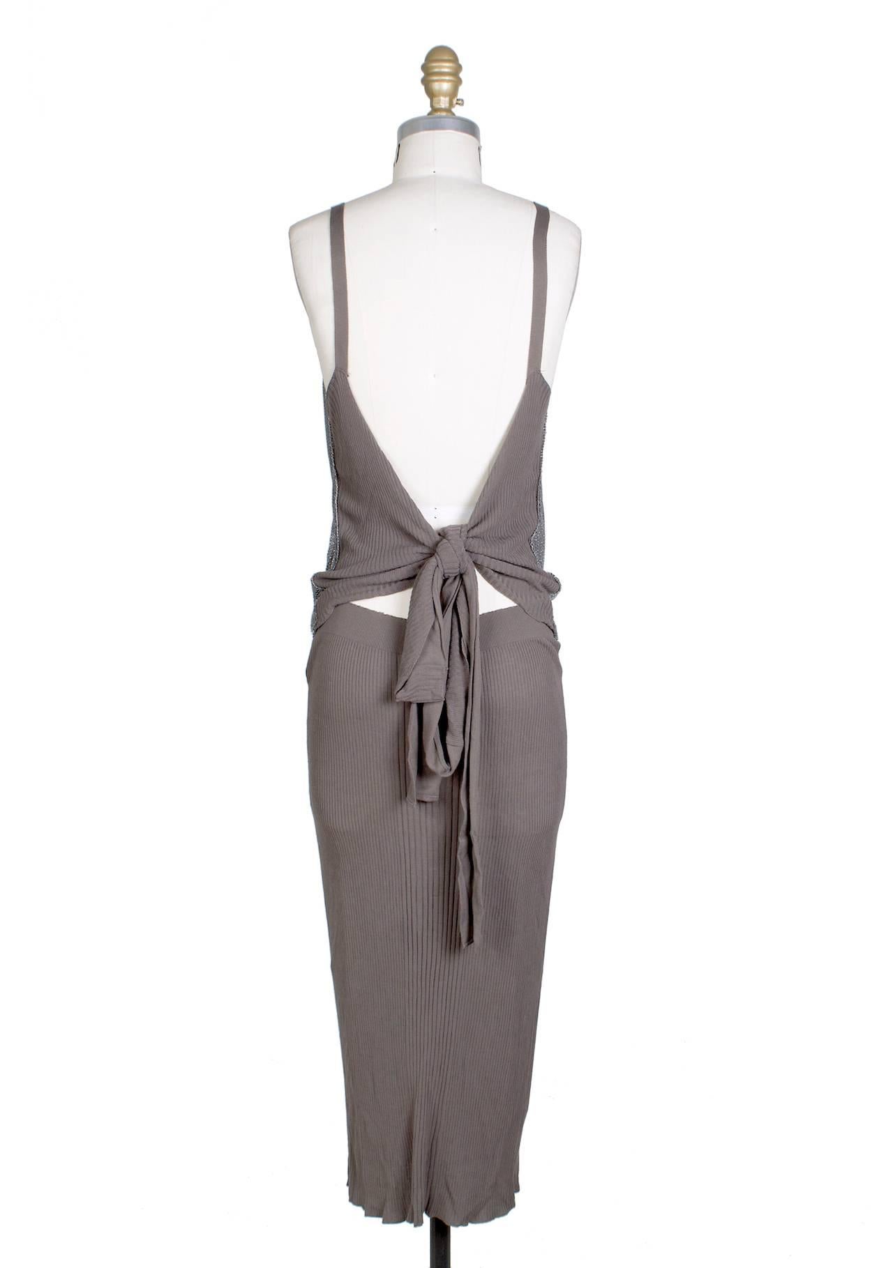 This is a dress by Jean Paul Gaultier c. 1990s. It features a draped chainmail bust and a knit cotton tank fabric skirt.  It ties in the back.  The knit material is stretchy. 