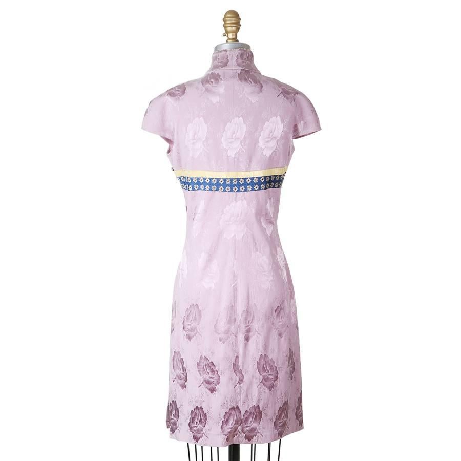 This is a dress by John Galliano for Christian Dior c. 2000s.  It features an embroidered mandarin collar, asymmetrical front button neckline closure.  The lavender fabric also has a large scale pattern of lotuses.