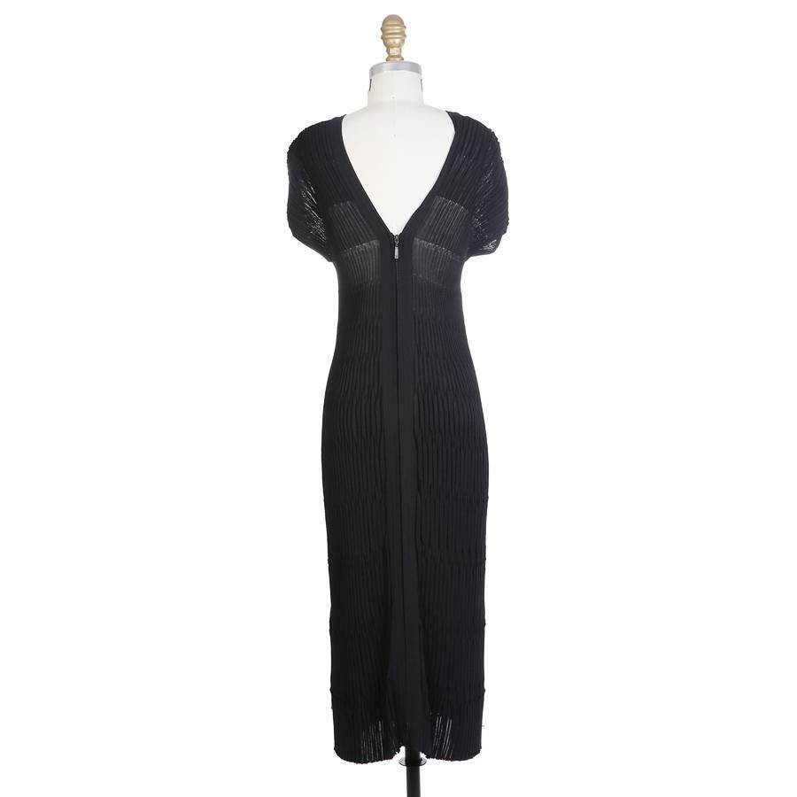 This is a dress by Chanel.  Made from a textured stretch ribbed fabric of cotton and nylon.  It features a cap sleeve, V neckline, and has a double zipper down the entire front.