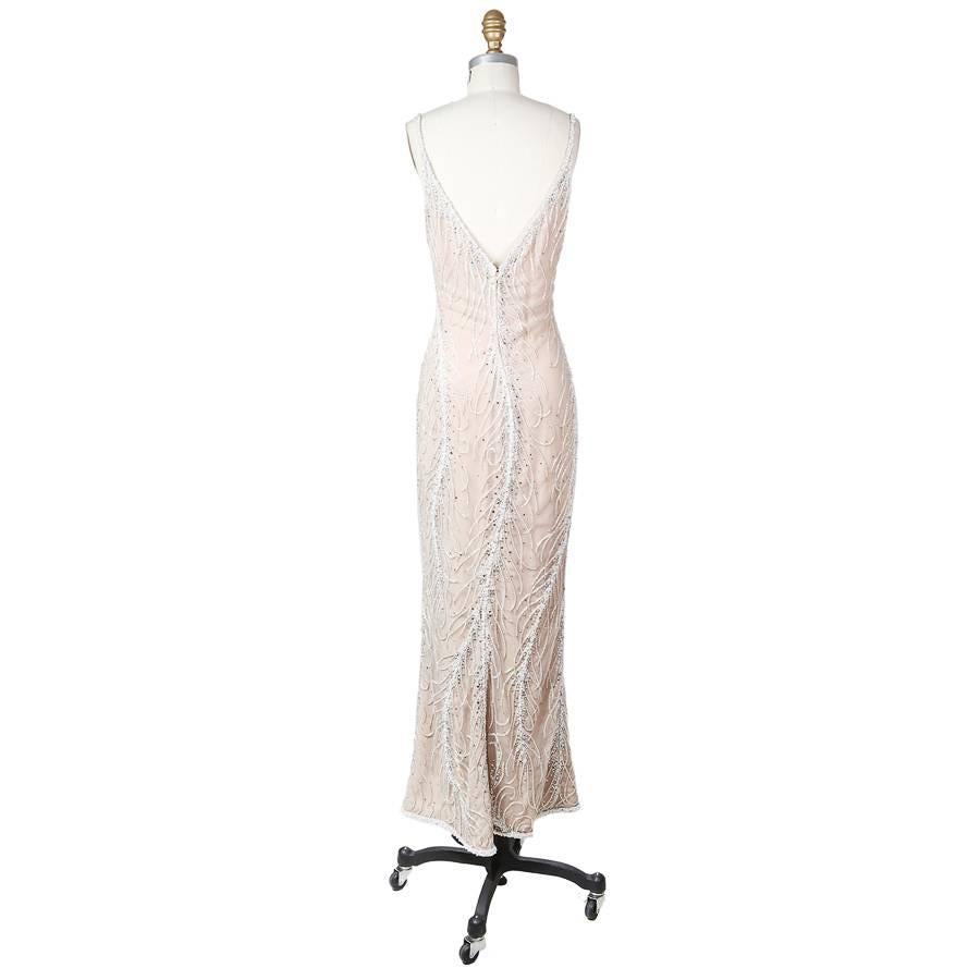 This is a dress by Bob Mackie. It has a blush chiffon lining with an overlay of beaded and rhinestoned mesh.  It features a tulip hem and has a back zipper closure with a top hook and eye.