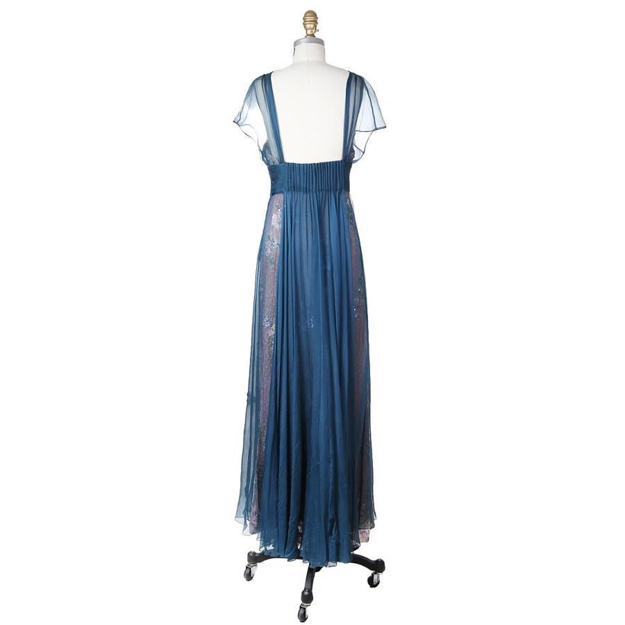 This is a vintage Valentino dress circa 1980s/1990s.  It features ruching around the waist which drapes down in the back.  It has a floral motif with a sheer blue chiffon overlay.  Side zipper closure with a top hook and eye.