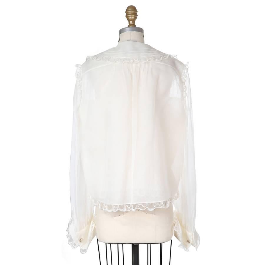 This is a multiple layer silk blouse from Chanel.  It features a delictae scalloped ruffle trim and has a button down closure.

16