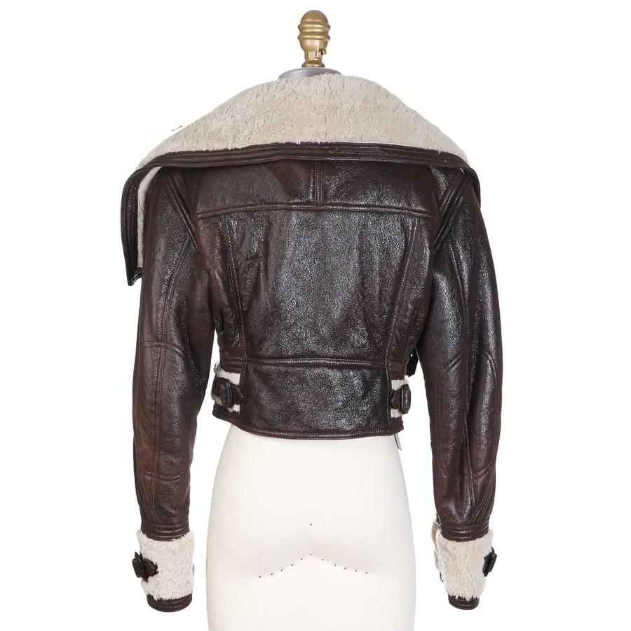 This is a jacket from Burberry.  Made from a dark brown leather and shearling, it has a cropped fit and features buckle details on the waist and cuffs.  It has an oversized collar and front zipper closure.  

16
