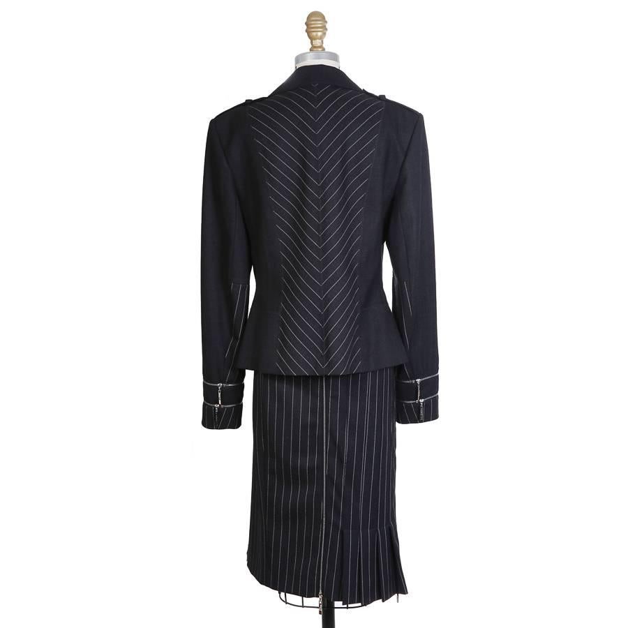 This is a navy blue wool blazer by John Galliano for Christian Dior.  It has pin striped panels and two vertical zippers on the front.  Also features shoulder tabs with a button, two zippers around the wrist cuffs, and a special pierced button in