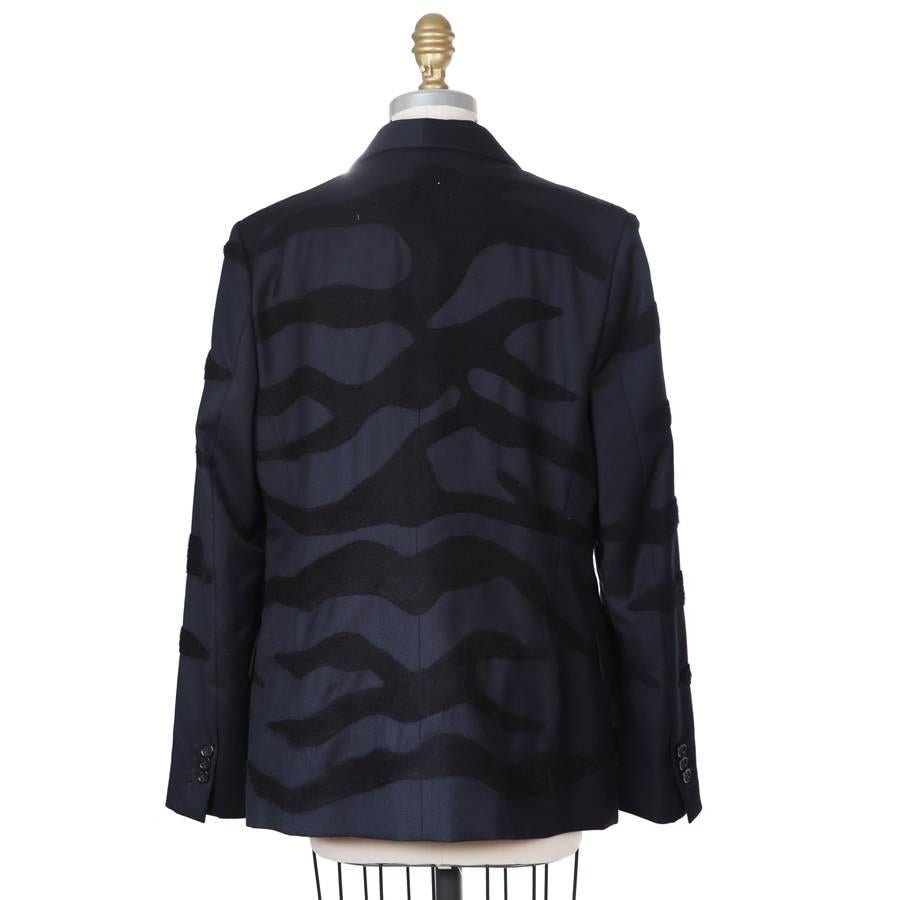 This is a navy wool blazer from Maison Margiela.  It features a subtle texture of wool tiger stripes and has a single breast closure and rounded lapel.  Lana wool twill outer, cotton lined.

16.75