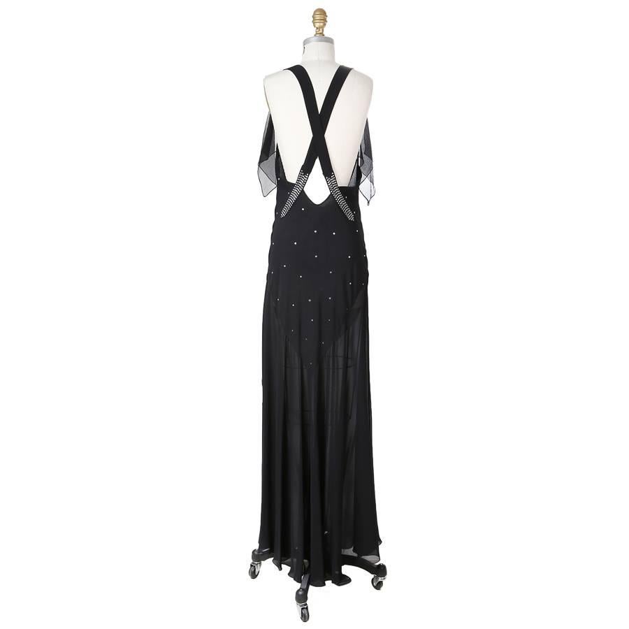 This is a silk chiffon dress by John Galliano featuring rhinestoning on the bust and straps.  The front has a draped bust and there are criss cross straps in back.