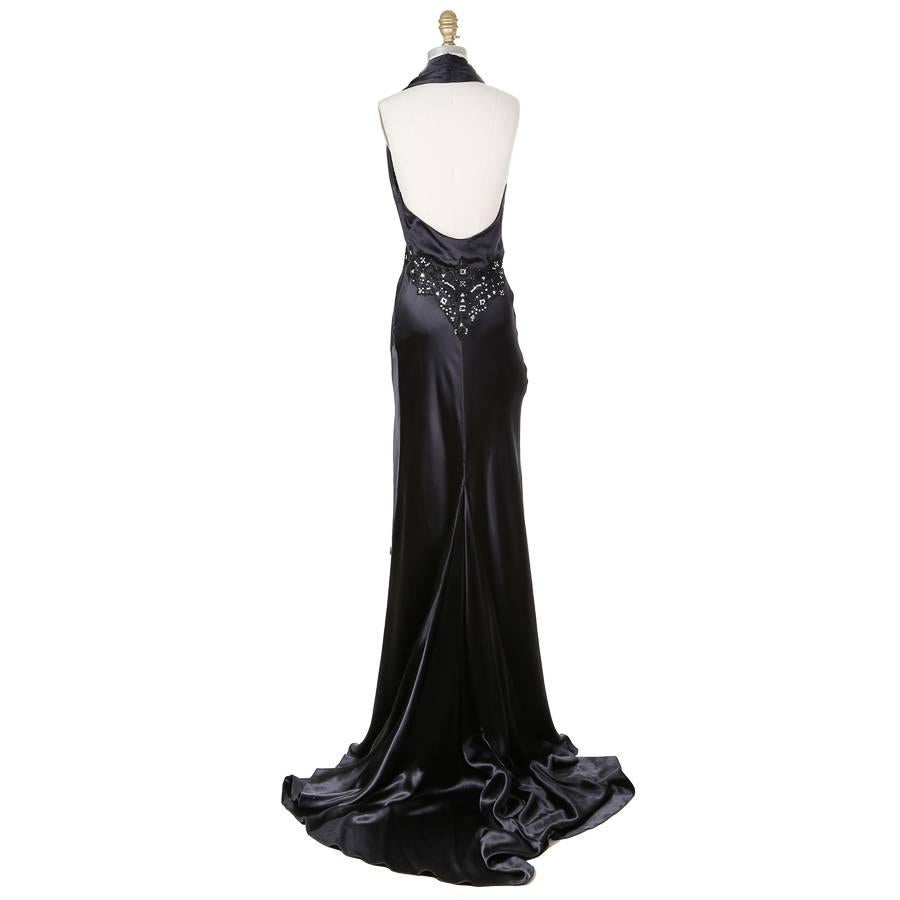 This is a dress by Hermes featuring an embellished waistline.  It is made from a silk satin and has a halter neckline.  