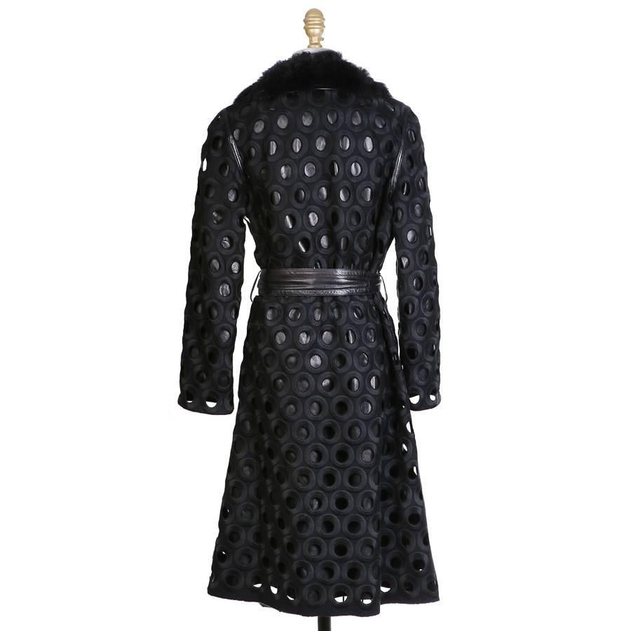 This is a winter coat by Marc Jacobs circa late 2000s.  It features a black leather base with wool ring shaped circular cut outs.  It also has a black faux fur collar, lined in silk, and includes a matching leather belt.  Single hook and eye closure