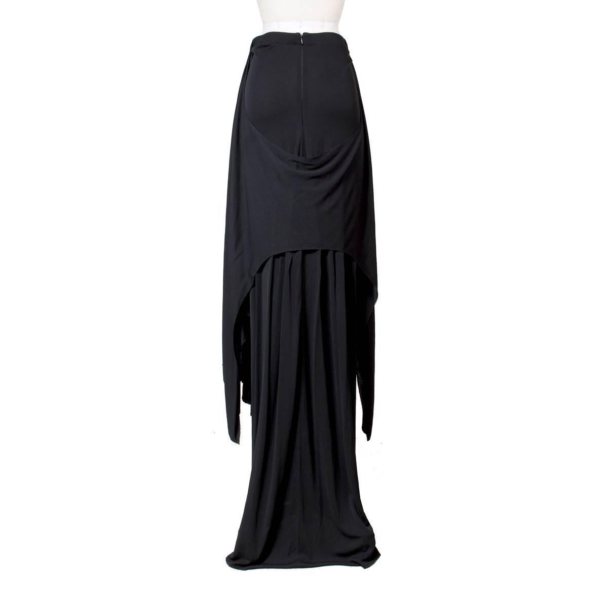This is a black maxi skirt by Jean Paul Gaultier c. 2000s.  It features a drape to create angles from front to back.  Hidden back zipper closure.