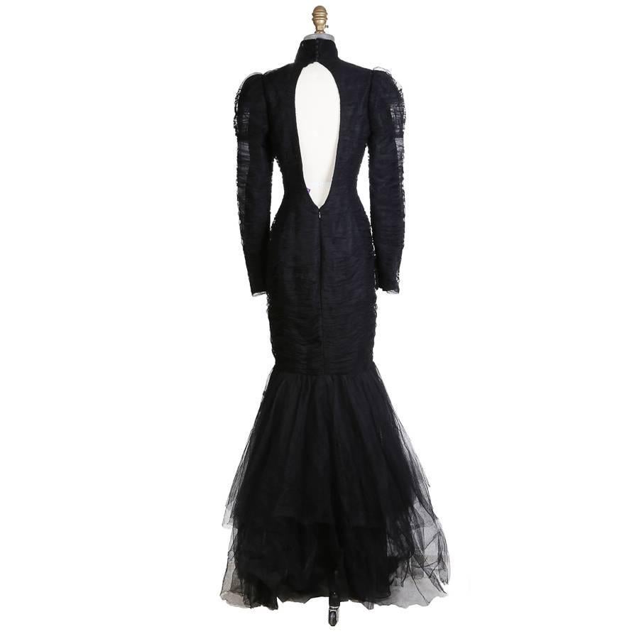 Gown by Ralph Lauren of black ruched tulle.  It features a collar with silk covered buttons in back.  

15