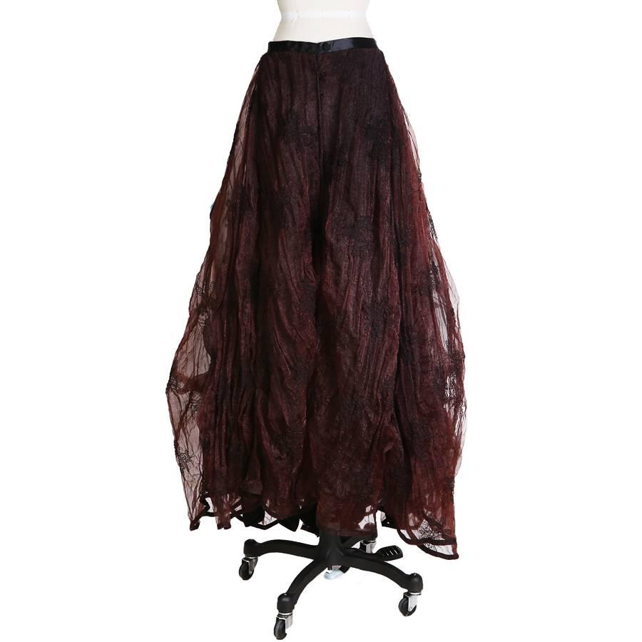 This is a ball gown skirt by Kaat Tilley.  It features a black lining with voluminous crinkled burgundy/black tulle.  It has a black satin waistband.  Tilley's work was inspired by whimsy and fairytales.