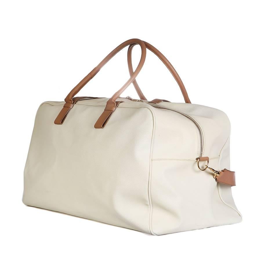 This is a duffle bag by Bottega Veneta.  It is cream colored leather with tan leather straps and gold hardware.  

Dimensions:  21