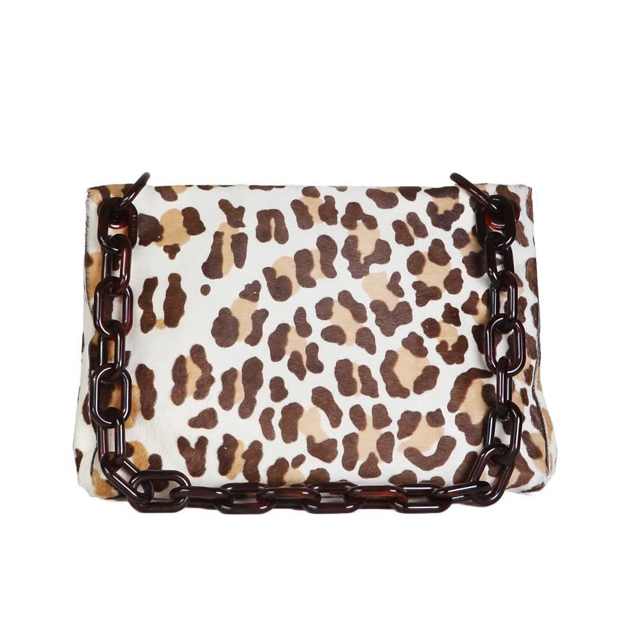 This is a shoulder bag by Prada.  It features a leopard print of calfhair.  The strap is a dark amber colored lucite chainlink.

Dimensions:  12.5