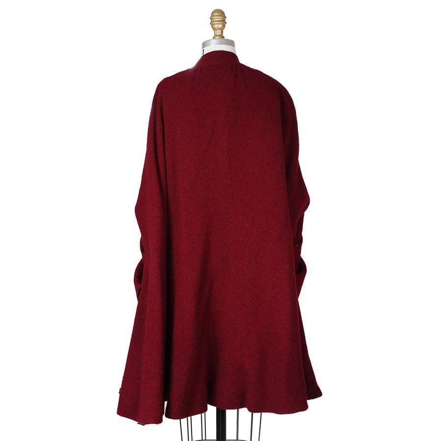 This is a vintage wool poncho by Pauline Trigere.  It features a double breast closure, arm holes with corresponding pockets, and lined in a matching satin.