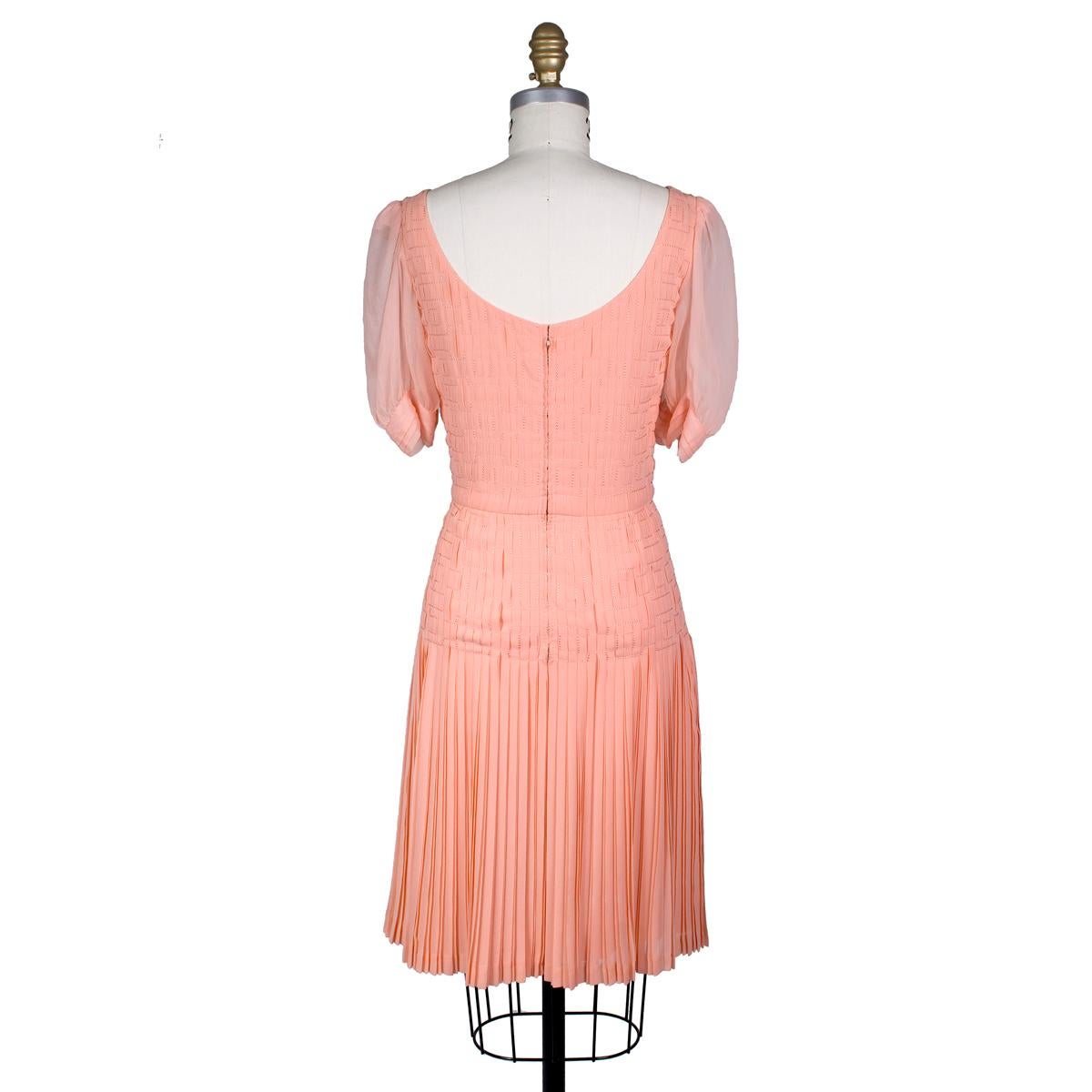 Vintage dress by Coco Chanel
Peach pink silk chiffon with stitching and pleating details 
Sheer puff style sleeves
Condition: Excellent vintage condition

Size/Measurements:
32