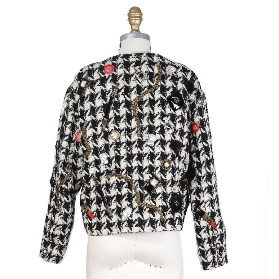This is a wool houndstooth cardigan from Chanel c. 1980s.  It features sequin, bead, and embroidered patches and has snap hidden snap closures down the front.  
Shoulder to shoulder is 17.5