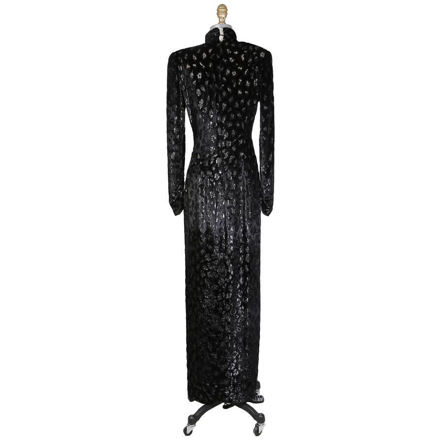This is a dress by Bob Mackie c. 1980s.  It features a metallic cheetah print from burned out velvet.  It has an asymmetrical curved seam down the front with a slight drape at the waist and a slit down the side.  High collar neckline, sheer silk