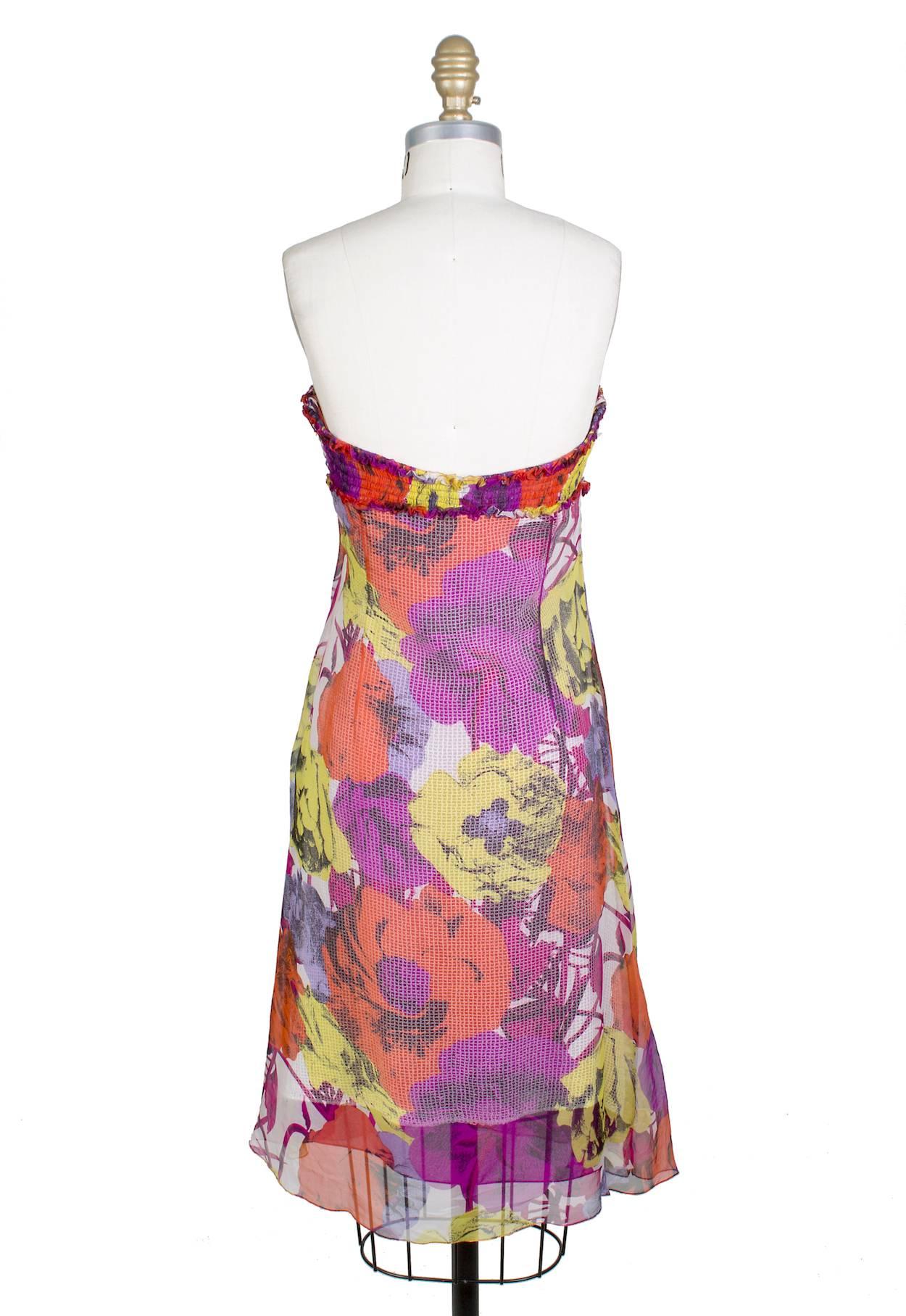 This is a strapless dress from Versace circa 1990s.  It features a bright bold floral  pop art print on a sheer silk overlay.  The bust has elastic ruching.