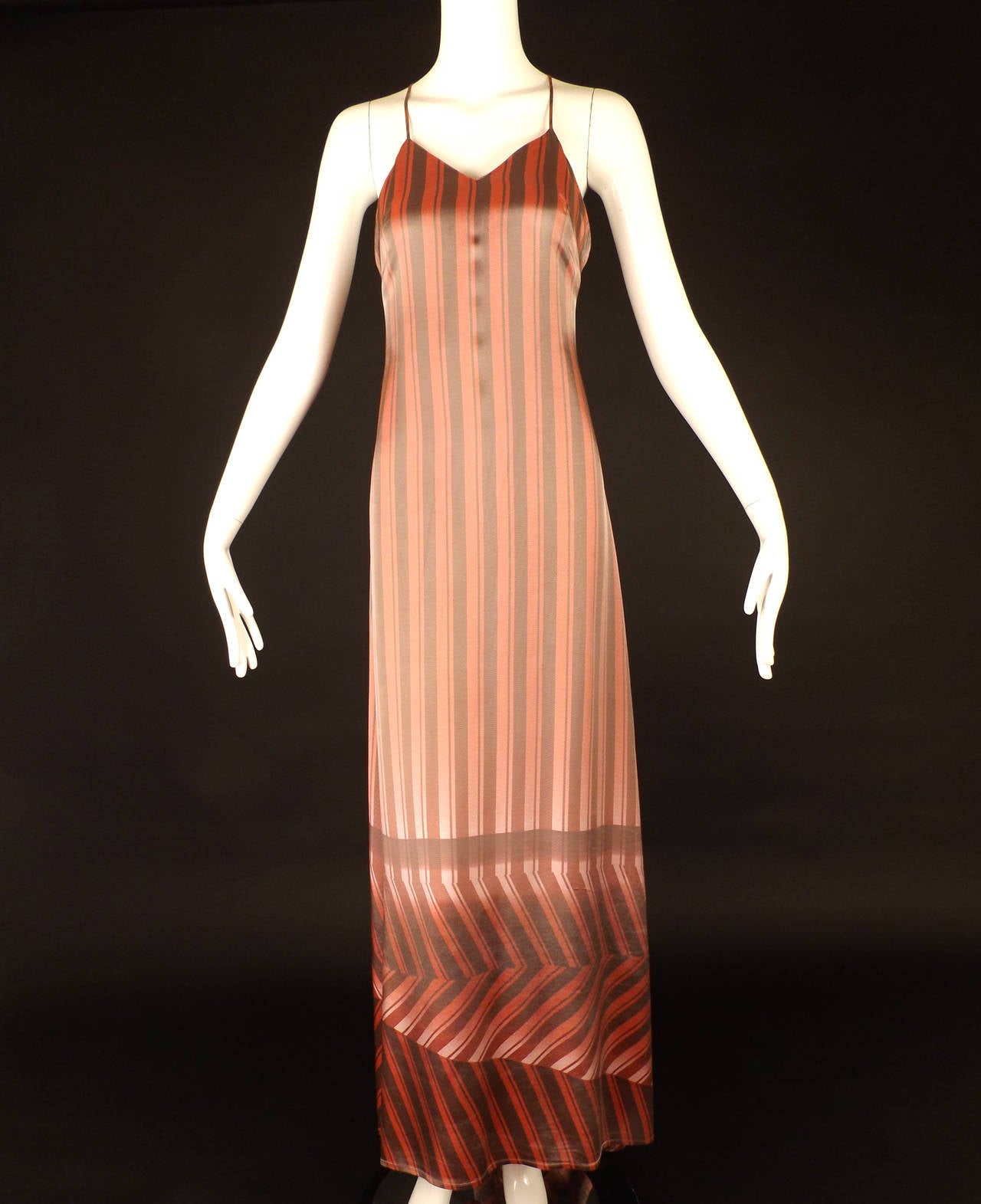 This is a late 1990s evening gown in a rayon lend satin with a pink and gray stripe pattern. The slip dress has spaghetti straps that criss cross in back. Dart fitted from the bust points to the side seams.   The dress falls slender with a sweeping