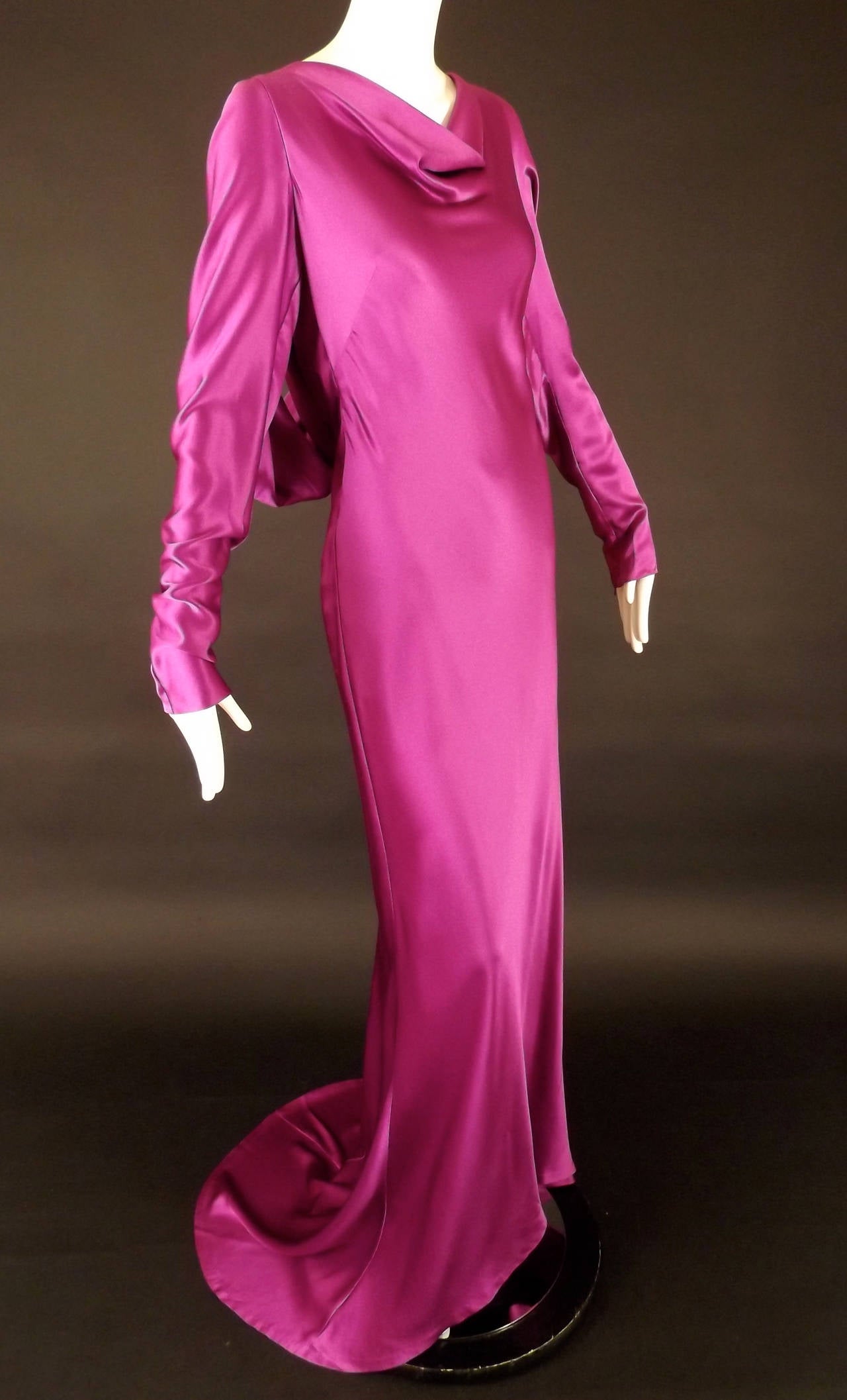 2007 Evening gown in a gorgeous raspberry silk crepe back satin.  The gown has a draped neckline and diagonal bust darts from the side seams. Long, set in sleeves taper to the zipper closures at the wrists.  Only a true designer (and pattern maker)